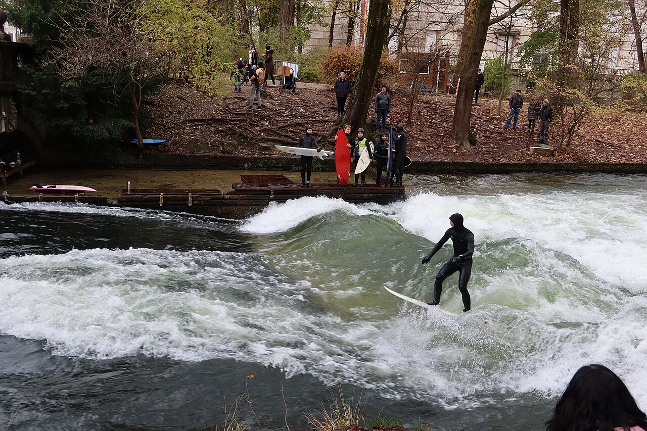 Surfer auf der Eisbachwelle am Eingang des Englischen Gartens